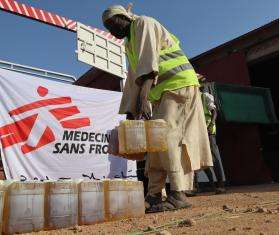 MSF staff offload a truck in preparation for a food distribution on the outskirts of Nyala, South Darfur.