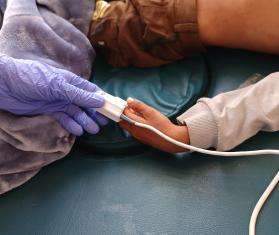 A nurse checks vital signs for a pediatric patient in Yemen. 