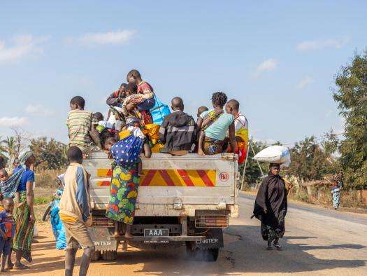 People ride in the back of a truck in Mozambique. 