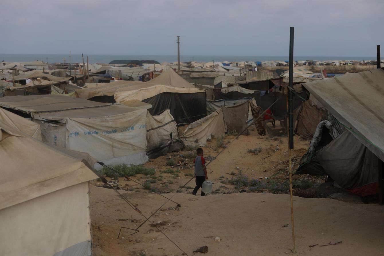 A child walks through a tent for displaced people in Gaza.