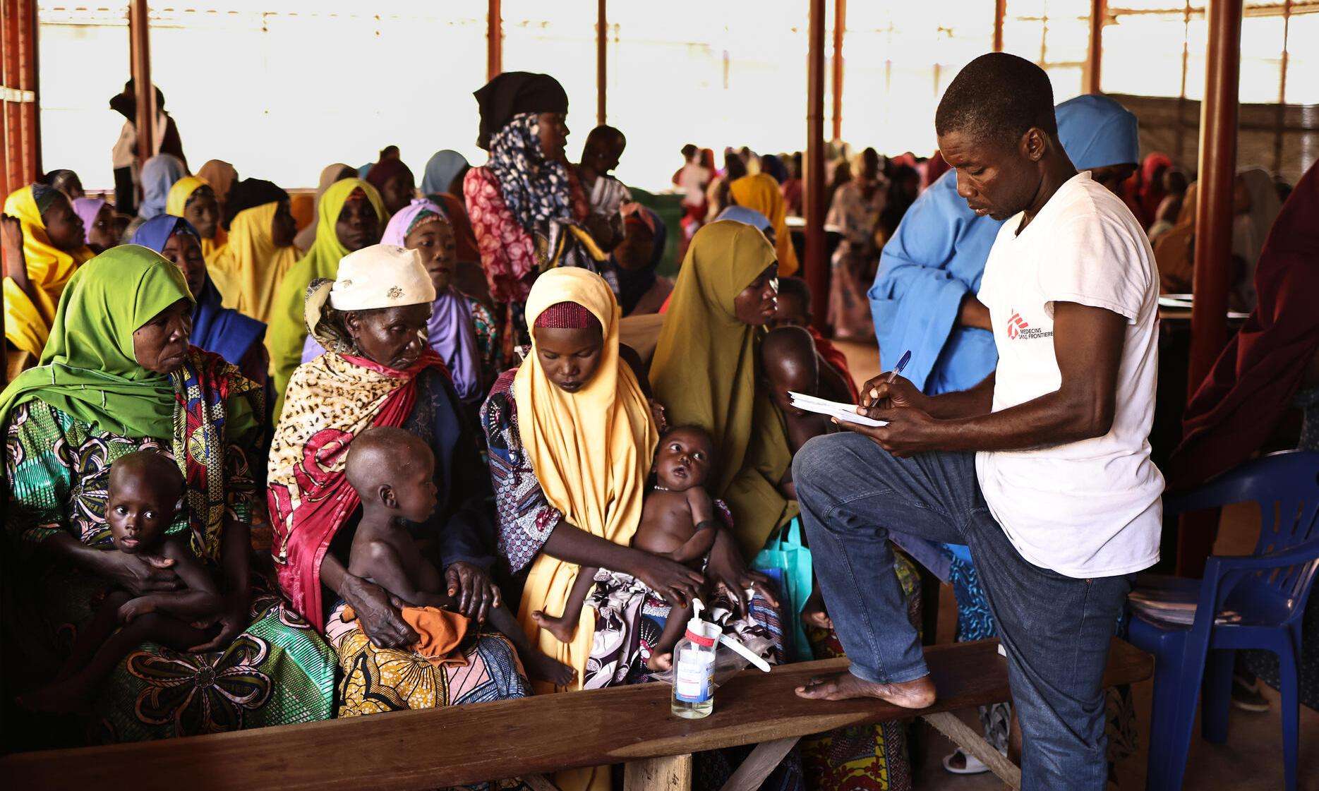 An MSF staff member takes information from new patients at the outpatient therapeutic feeding center in the Jega local government area of Kebbi state.