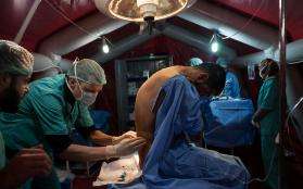 An MSF anesthesiologist examines a patient before beginning a medical procedure.