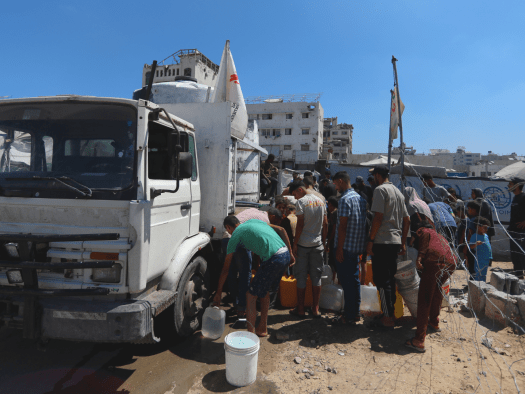 Palestinians queue for water outside an MSF water truck in Gaza.